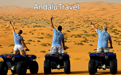 Tres personas montadas en quads posando en el desierto.