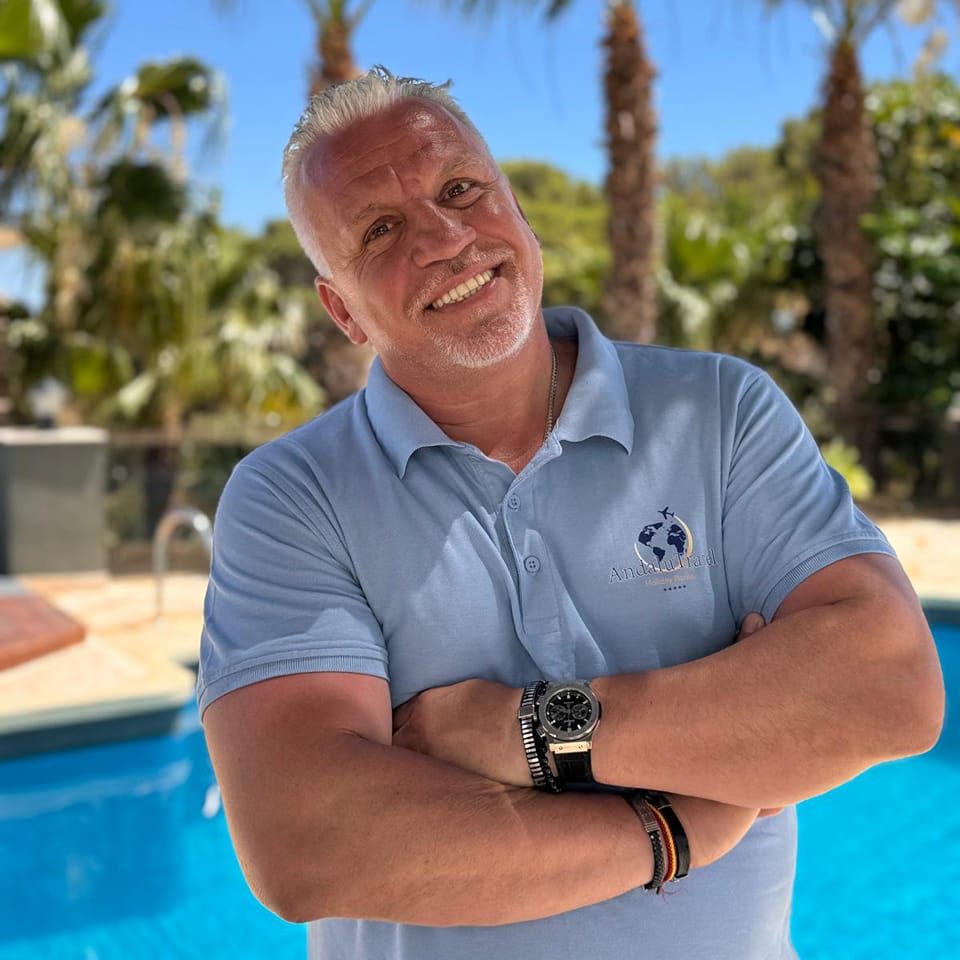 Co-fundador de la empresa posando con los brazos cruzados y una gran sonrisa con una piscina de fondo.